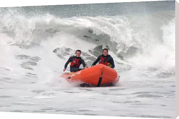 Two lifeguards on an arancia IRB in surf at St Agnes