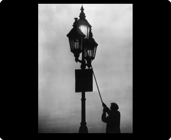 A lamplighter at work in the London fog