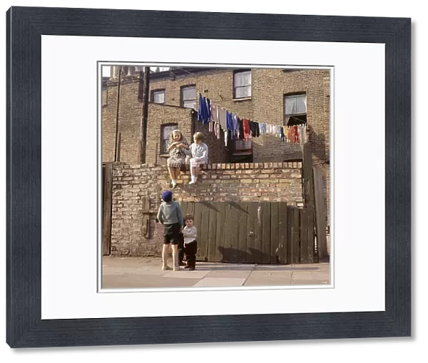 Chldren on a wall, with washing, Balham, SW London