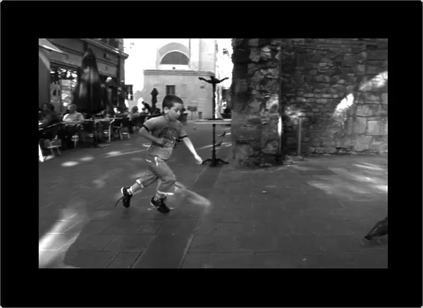 Boy chasing a pigeon Avignon France