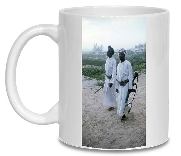 Omani elders wearing Khanjar and carrying rifles in Oman
