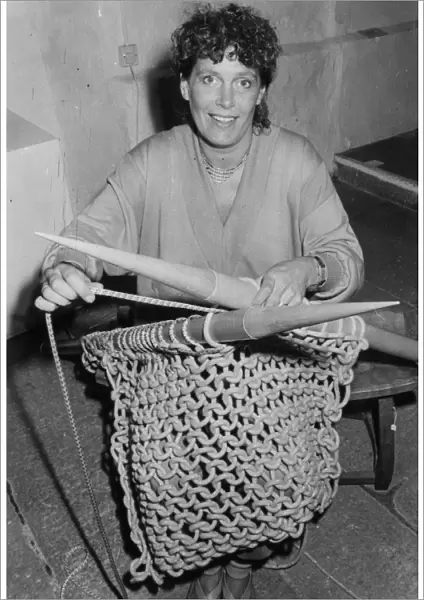 Woman knitting with six foot needles