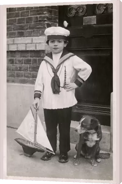 Young lad in sailor suit with pet dog and model ship