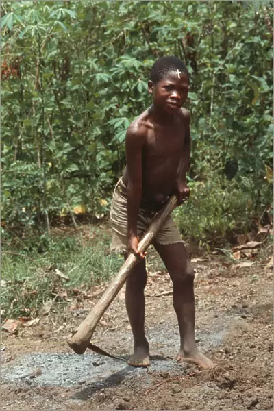 Barefoot boy with mattock, Sierra Leone