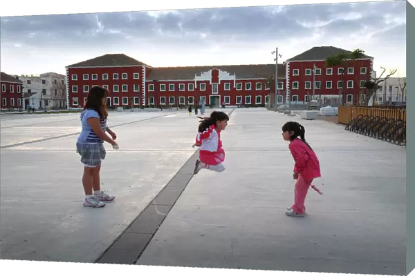 Three girls with skipping rope - plaza, Es Castell, Menorca