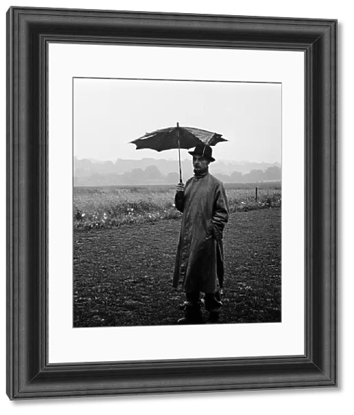 Man with broken umbrella stands in pouring rain