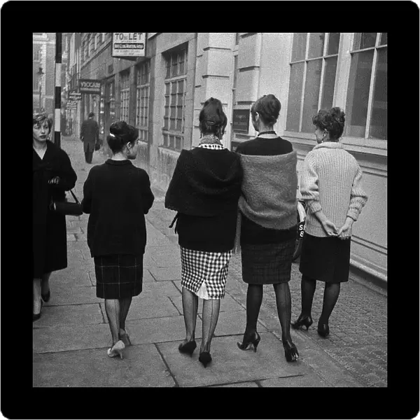 Four young women walking along a street, London