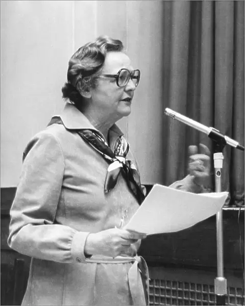 Jessica Mitford speaking at a microphone