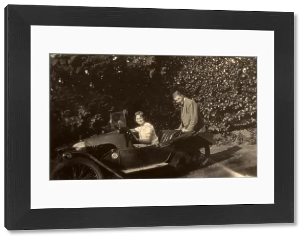 Couple in a tiny three-wheeled car