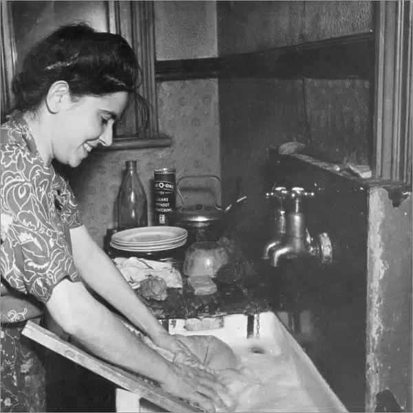 Young woman washing clothes at a sink