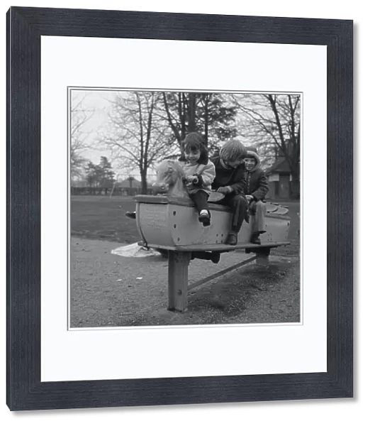 Three children on a playground ride