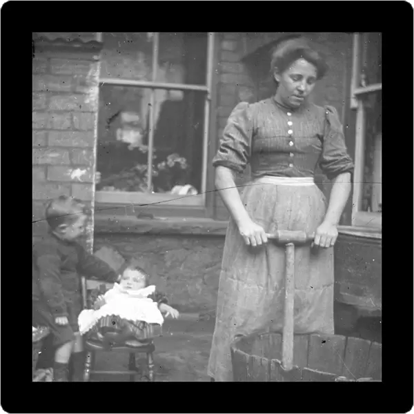 Woman using a dolly tub in a back yard, South Wales