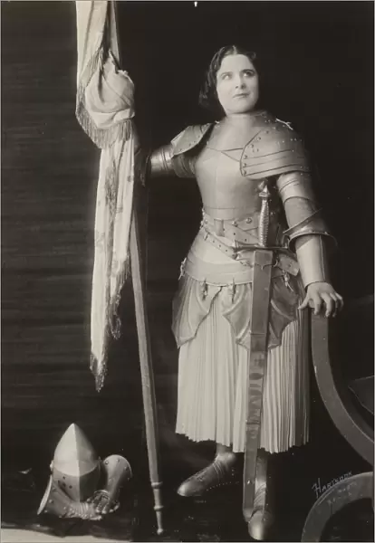 Geraldine Farrar, dressed in costume as Joan of Arc, holding