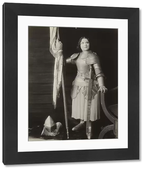 Geraldine Farrar, dressed in costume as Joan of Arc, holding