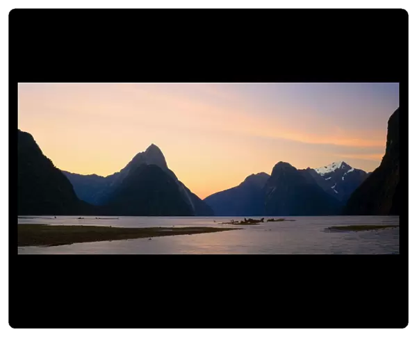 Milford Sound with landmark Mitre Peak and surrounding mountains just after sunset. Milford Sound is one of the, if not THE, most famous attraction in New Zealand