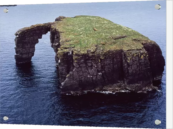 Aerial image of Scotland, UK: Dore Holm, a small islet with a natural arch, off the south coast of Esha Ness, in the west of Mainland, Shetland