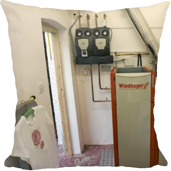 Windhager Austrian wood pellet fired domestic biomass boiler produces heat for thermal store using small wood pellets supplied from a large external hopper installed in small cottage Cotswolds UK