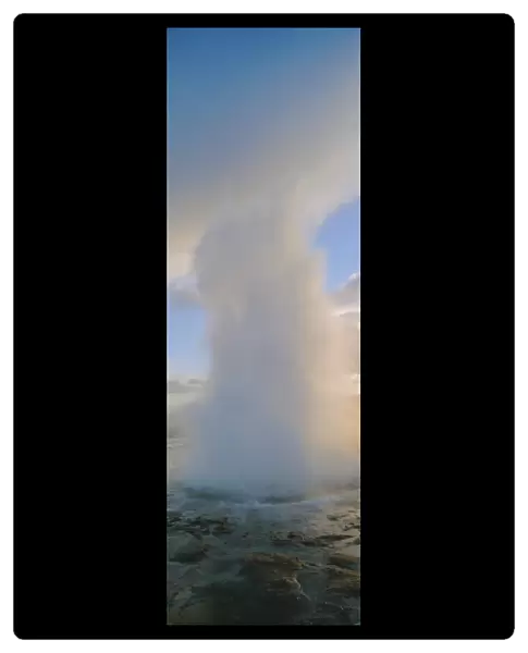 Geyser erupting. A geyser is a deep natural well in a geothermal rock fissure