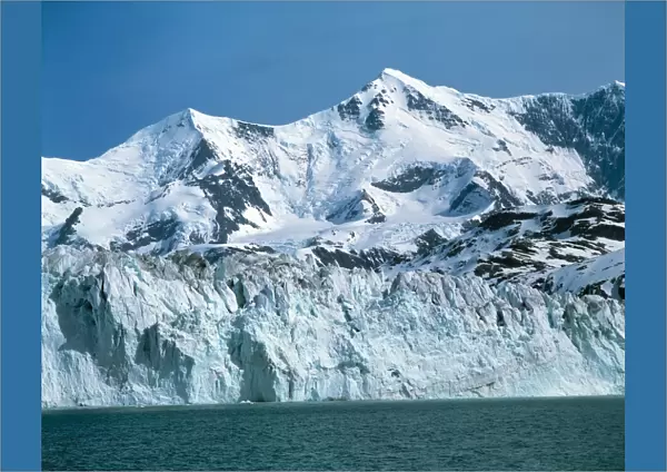 Glacier with mountains behind. A glacier is a body of ice that forms when