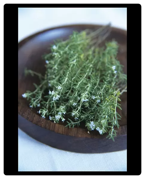 Thyme. Sprigs of flowering thyme (Thymus vulgaris) in a wooden bowl