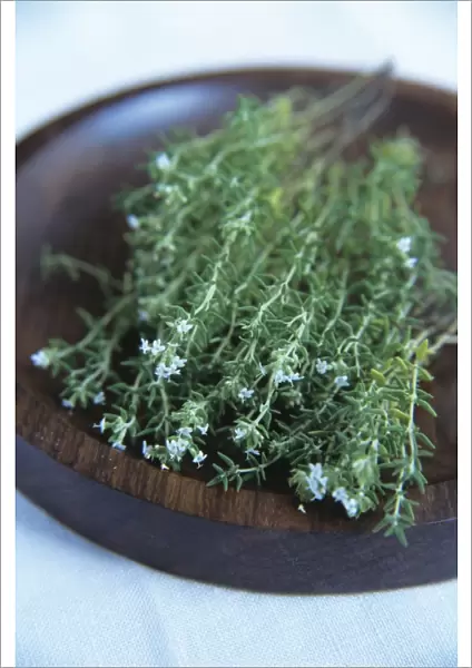 Thyme. Sprigs of flowering thyme (Thymus vulgaris) in a wooden bowl