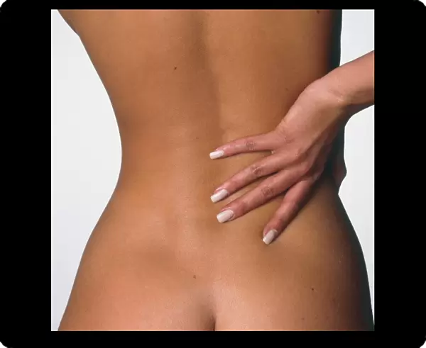 Back pain: womans hand held to her lower back