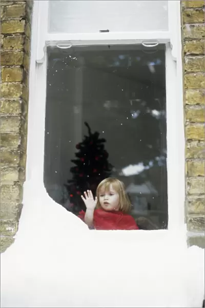 Girl staring out of snowy window