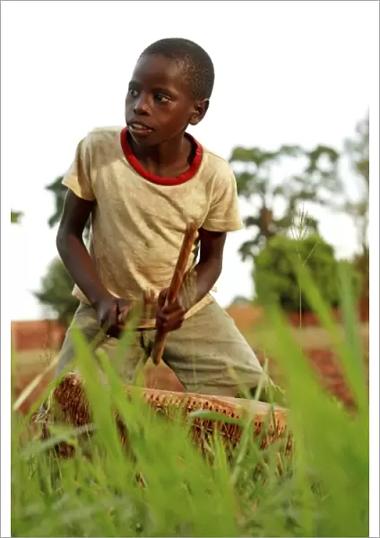Boy playing a drum, Uganda