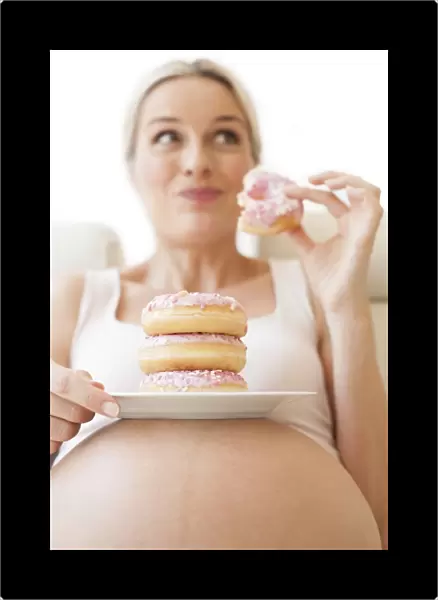 Pregnant woman eating doughnuts