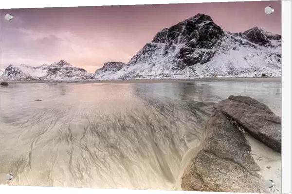 Sunset on the surreal Skagsanden beach surrounded by snow covered mountains, Flakstad