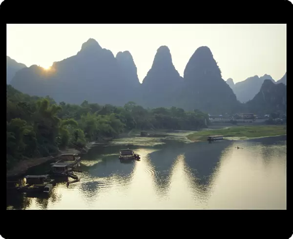 In Guilin limestone tower hills rise steeply above the Li River, Yangshuo