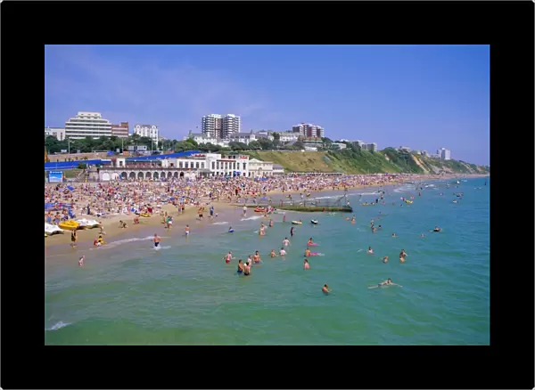 Holidaymakers in the sea and on the beach, Bournemouth, Dorset, England, UK