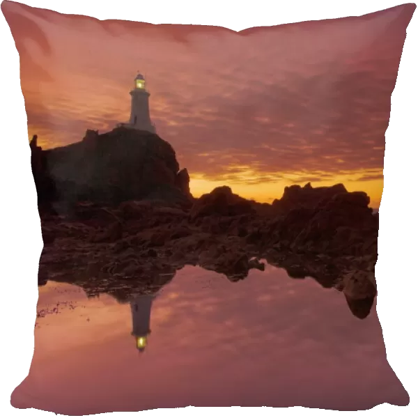 Dramatic sunset and low tide, Corbiere lighthouse, St. Ouens, Jersey, Channel Islands