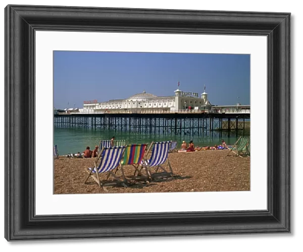 Empty deck chairs on the beach and the Brighton Pier, Brighton, Sussex