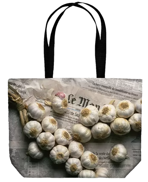 Strings of garlic spread out on Le Monde newspaper in France, Europe