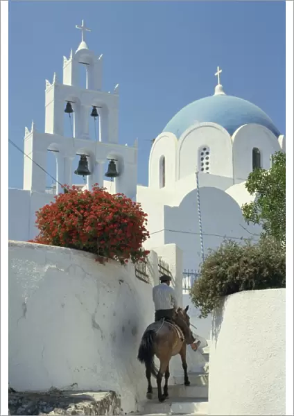 Figure on donkey passing church bell tower and dome