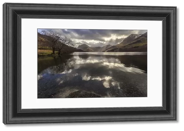 Winter reflections, shafts of sunlight break through clouds, Buttermere, Lake District
