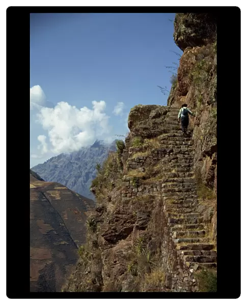 A walker climbs the steps on a narrow path along the