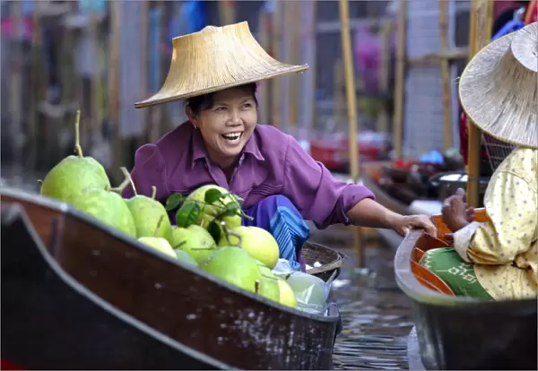 Local women share a joke at Damnoen Saduak Floating Market