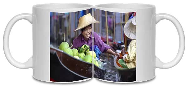 Local women share a joke at Damnoen Saduak Floating Market
