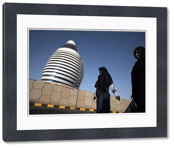 Locals walk past the 5-star Boji Al-Fateh Hotel (Libyan Hotel)