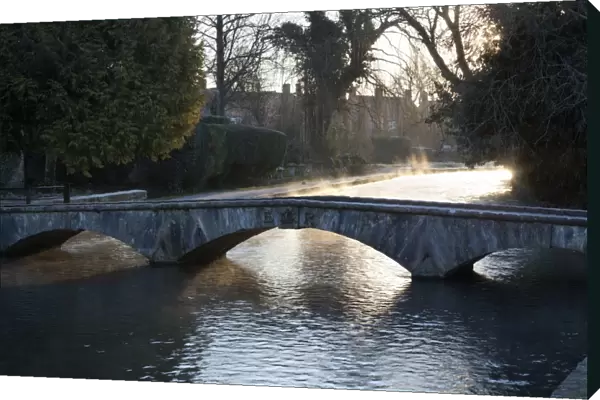 Cotswold stone bridge over River Windrush in mist, Bourton-on-the-Water, Cotswolds