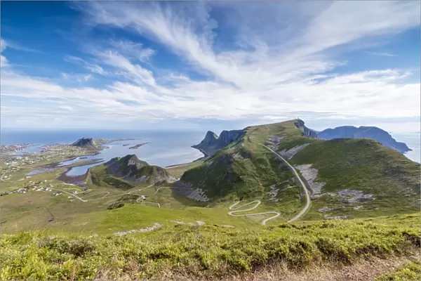 Steep road of curves in between green meadows and sea, Sorland, Vaeroy Island, county of Nordland