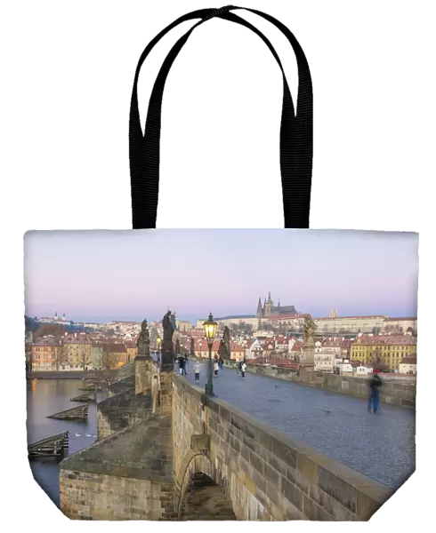 People on the historical Charles Bridge on Vltava River at dawn, UNESCO World Heritage Site