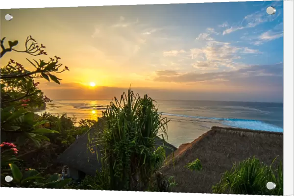 Surfers at sunset in Bali with straw roofed huts, Indonesia, Southeast Asia, Asia