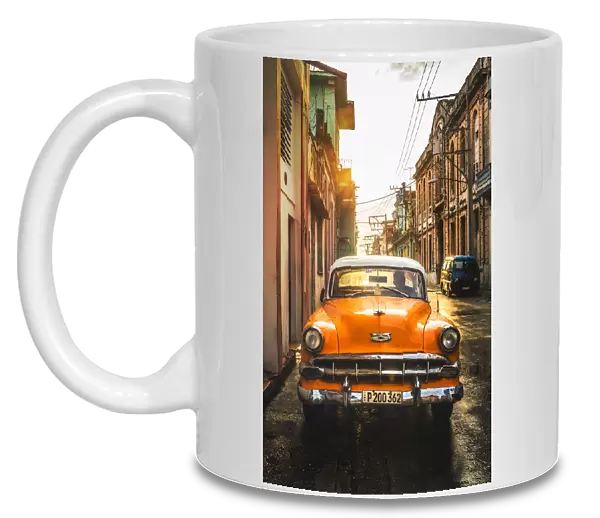 Orange American vintage car at sunset, La Habana (Havana), Cuba, West Indies, Caribbean