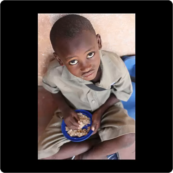 Child eating a meal in a primary school in Africa, Lome, Togo, West Africa, Africa