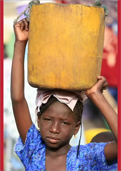 Girl carrying a heavy load, St. Louis, Senegal, West Africa, Africa