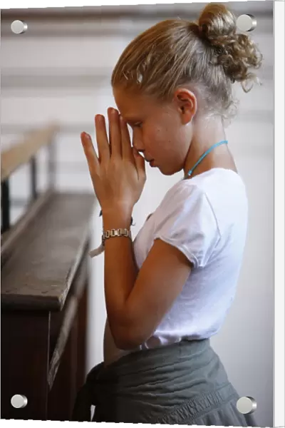 Girl praying in church, Saint Nicolas de Veroce, Haute Savoie, France, Europe