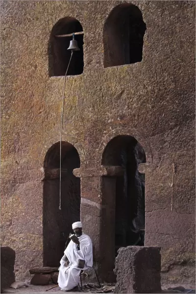 Priest reading a Bible in Bet Maryam church courtyard, UNESCO World Heritage Site